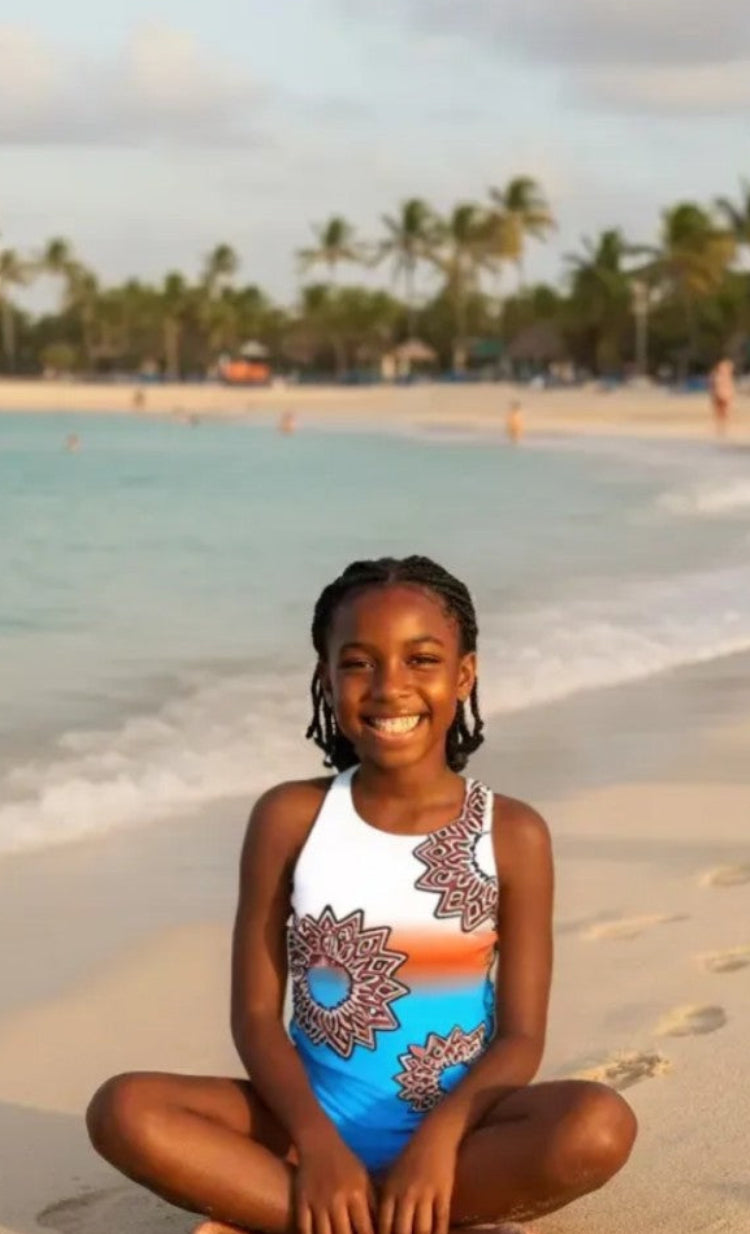 Focus girls one-piece swimsuit with artistic floral print, model on sandy beach, made in Canada