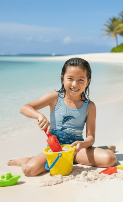 Flip 2 girls one-piece swimsuit with single dolphin print, model on beach, made in Canada